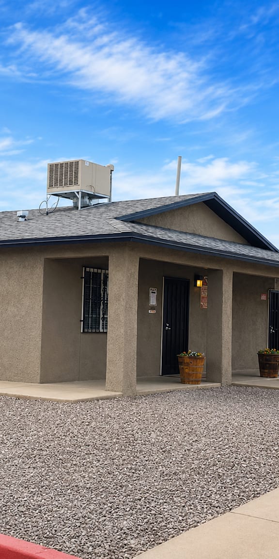A building with a grey roof and a red line on the ground in front of it.