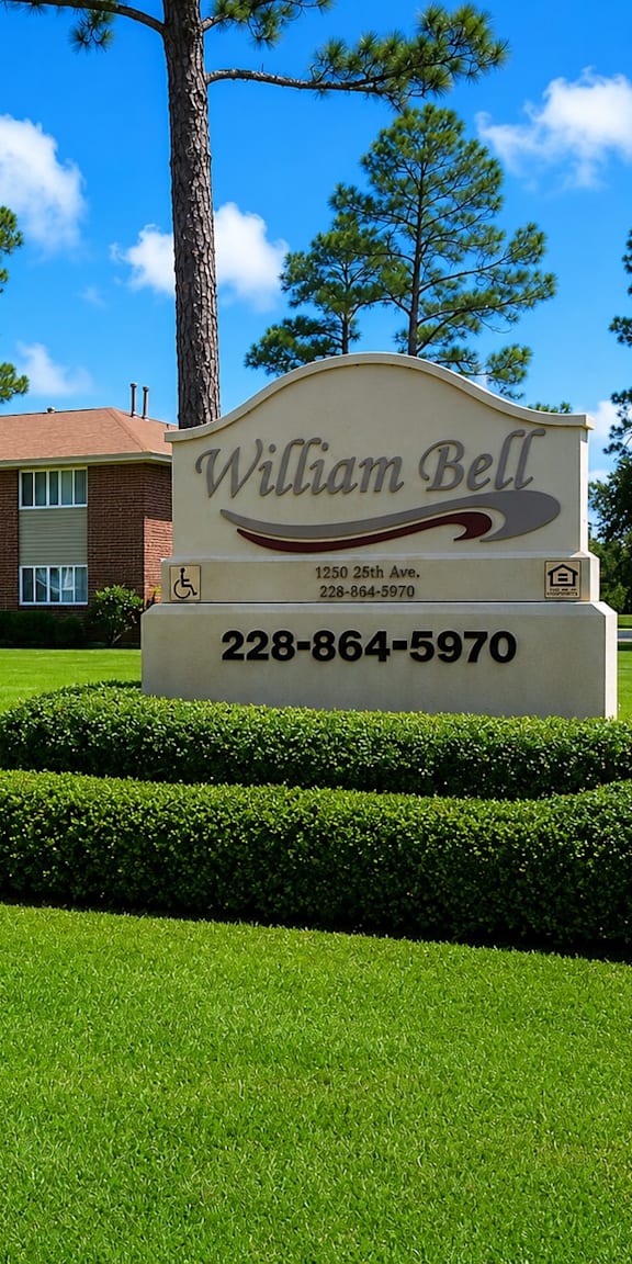 A sign for William Bell stands in front of a building and trees.