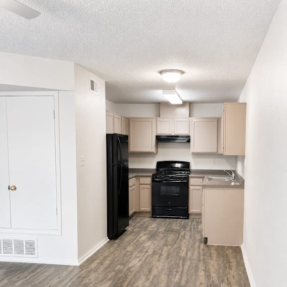 A kitchen with black appliances and white walls.