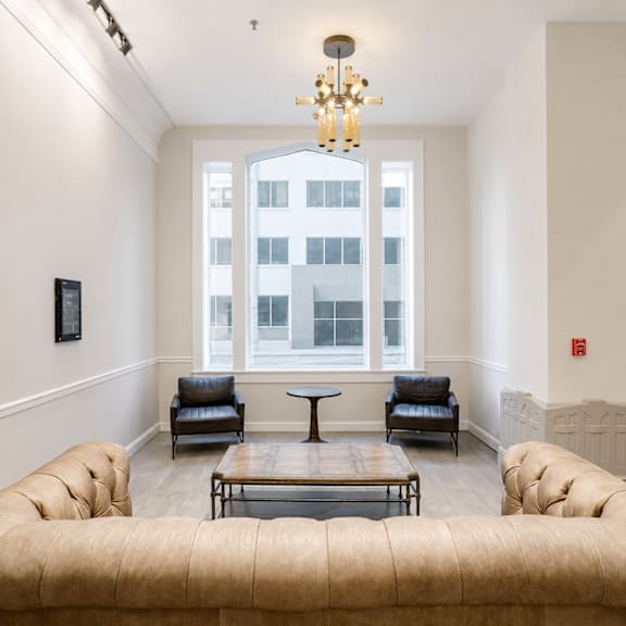 A living room with a large window and a chandelier.