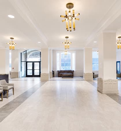 A large, well-lit lobby with a chandelier and a bench.