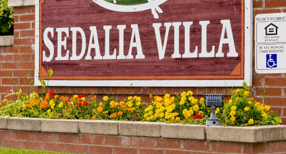 A sign for Sedalia Villa with a horse and rider on it.