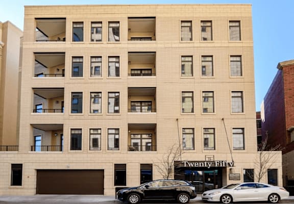 a large tan building with cars parked in front of it