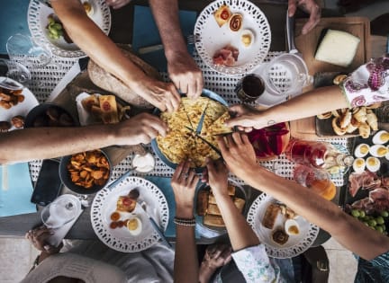 a group of people sitting around a table eating food