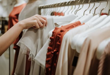 a woman looking at clothes on a rack