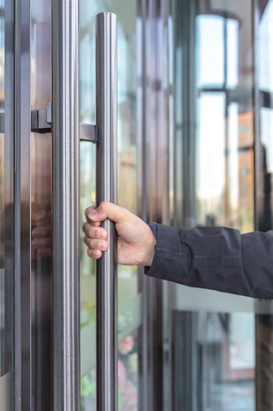 A person is opening a glass door.