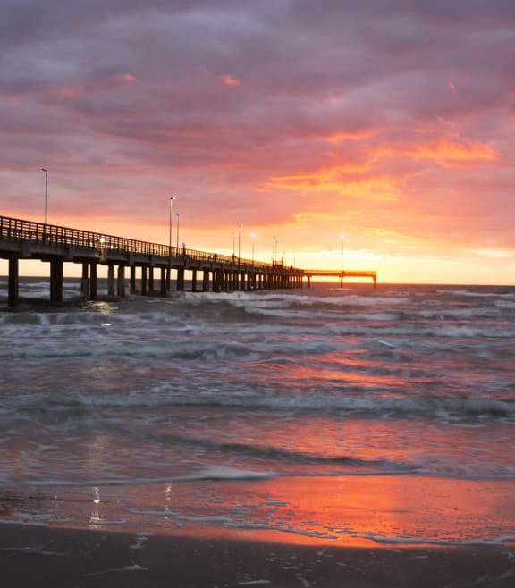 a pier with a sunset in the background