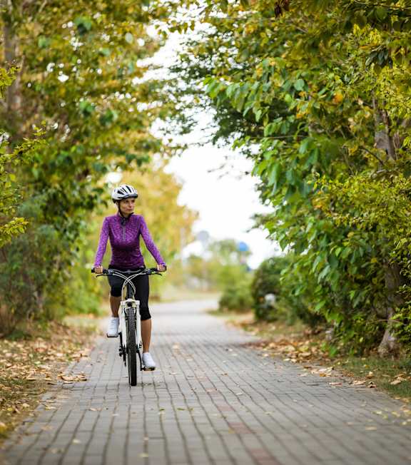 a woman riding a bike down a brick road