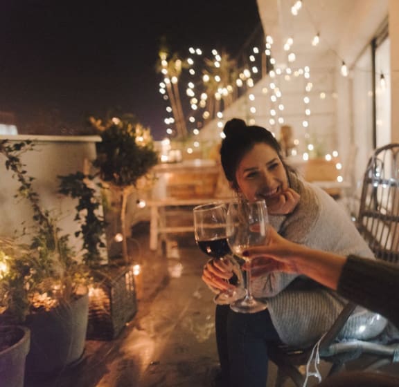 a woman sitting at a table with a glass of wine