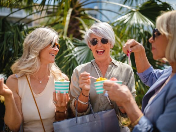 a group of women holding cups of ice cream