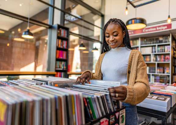 A woman is browsing through a collection of CDs in a store.