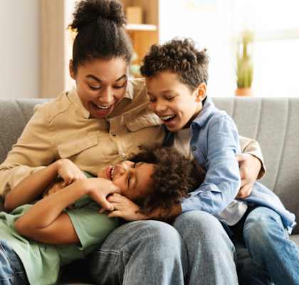 A woman and two children are sitting on a couch.