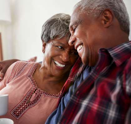 An older couple is sharing a moment together while drinking tea.