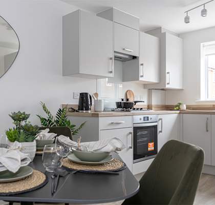 a kitchen and dining area with a table and chairs and a mirror