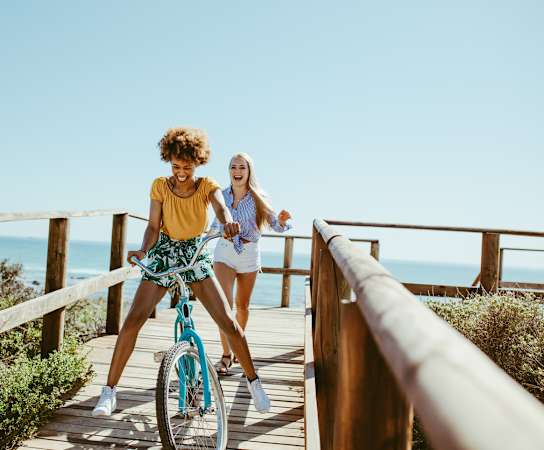 a woman riding a bike with another woman walking behind her at 511 Meeting, South Carolina