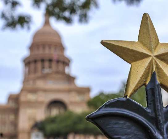 a gold star on a fence with a building in the background at Channings Mark, Austin, Texas