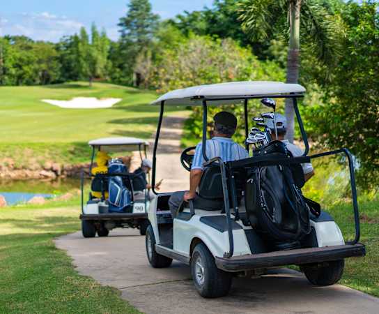people driving golf carts on a golf course at Village at Terra Bella Apartments, Land O' Lakes, Florida