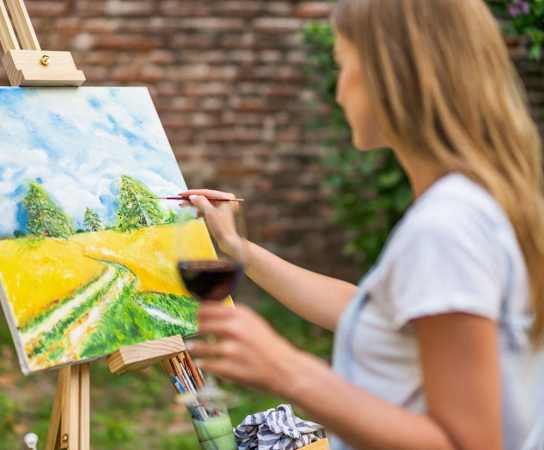 a girl painting a canvas with a glass of wine at Madison at the Arboretum, Austin, TX
