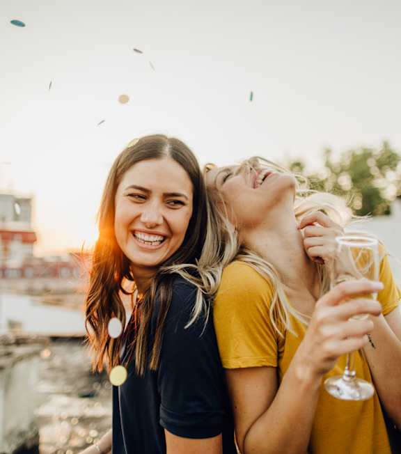 a group of girls drinking champagne on a rooftop