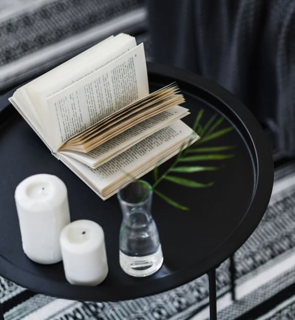 a small black table with a book and candles on it at Parke Place, Prescott Valley, Arizona