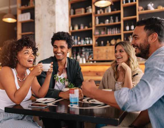 Four people are sitting around a table in a restaurant.