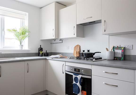 a kitchen with white cabinets and a stove and a window
