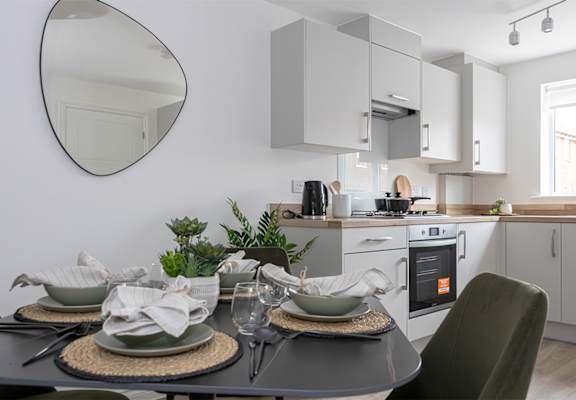 a kitchen and dining area with a table and chairs and a mirror