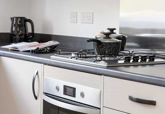 A modern kitchen with a stove top and oven.