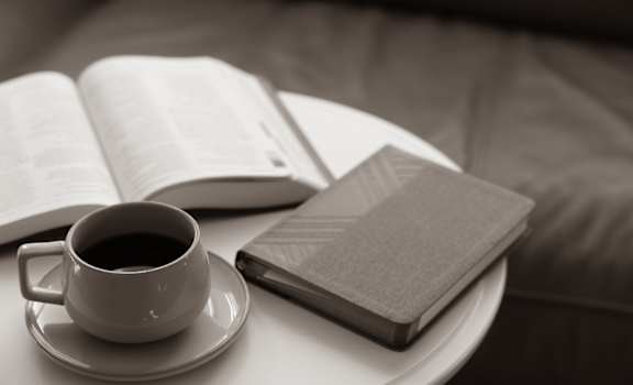 a cup of coffee and a book on a table at The District at Rosemary, Florida, 34236