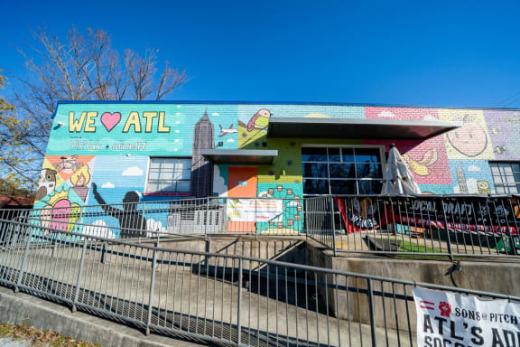 a mural on the side of a building with a fence at Glenwood at Grant Park Apartments, Atlanta, Georgia