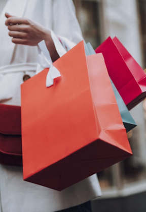 A woman is holding shopping bags in her hands.