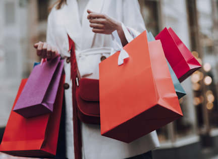 A woman is holding shopping bags in her hands.