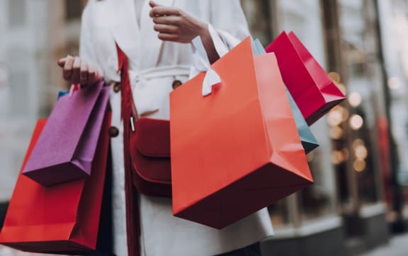 a woman carrying shopping bags and holding shopping bags at Cambridge Village in Houston, TX