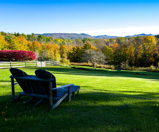 two adirondack chairs on a lawn with trees in the background  at Residences at Westborough Station, Westborough, MA