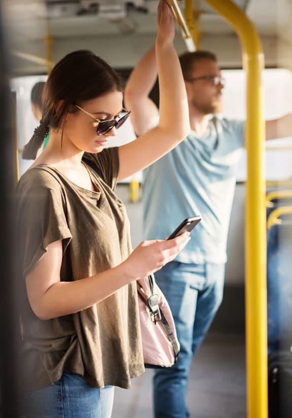 a group of people on a bus looking at their cell phones