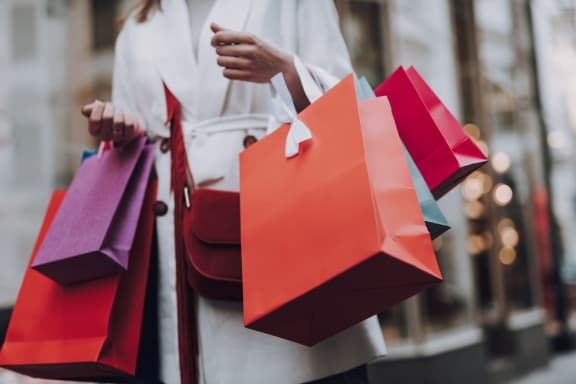 a woman carrying shopping bags and holding shopping bags at Whispering Oaks in  Conroe, TX