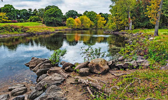 A serene landscape with a lake, rocks, and trees at Edmands House, Framingham, 01701