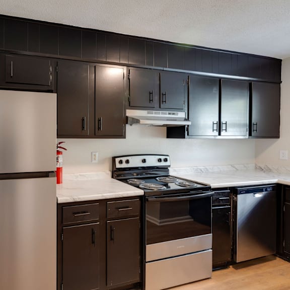 A kitchen with a stainless steel refrigerator and black cabinets. at Savan Pointe, Savannah, 31406