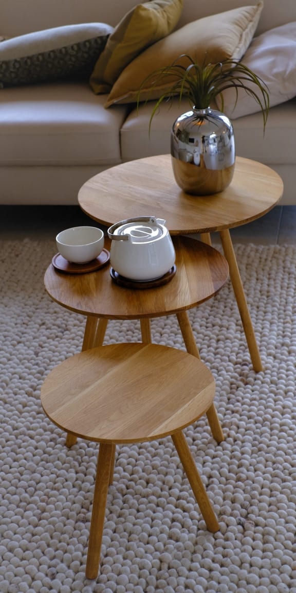 a living room with two coffee tables with a couch in the background