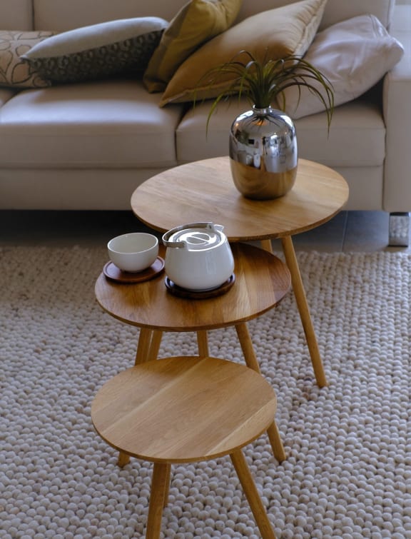 a living room with two coffee tables with a couch in the background