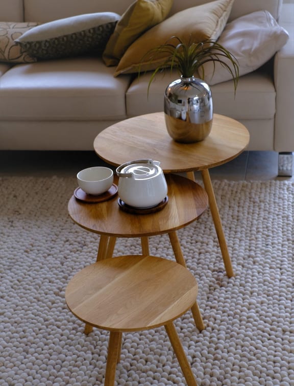 a living room with two coffee tables with a couch in the background