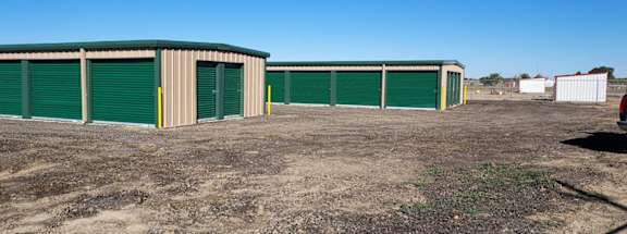 a group of garages and sheds in a dirt lot