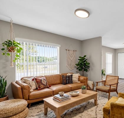 A living room with a brown sofa and a wooden coffee table.
