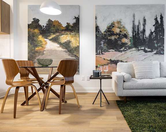 A living room with a green chair and a white sofa.at Petries Landing II Apartments, Ottawa, ON K4A 0S8