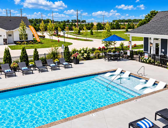 A pool with a slide in the background and a building in the foreground.