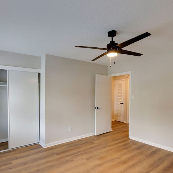 A room with a ceiling fan and wooden floors. at Savan Pointe, Savannah
