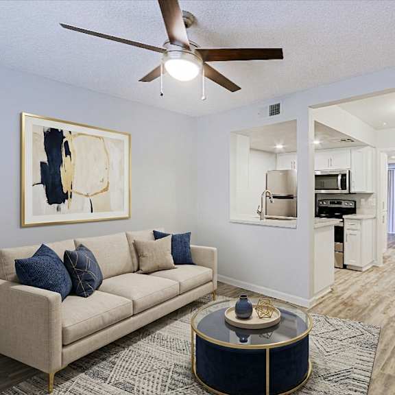 A living room with a beige couch and a painting on the wall.