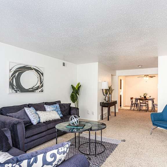 A living room with a grey couch and a blue chair.