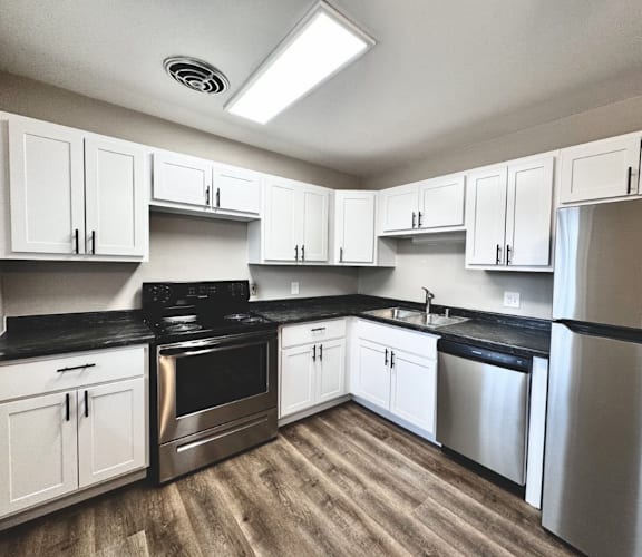 a kitchen with stainless steel appliances and white cabinets