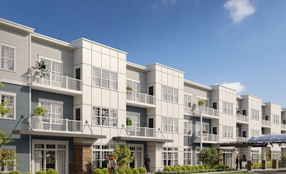 A row of modern apartment buildings with balconies and a covered walkway.